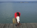 Méditation: Un homme assis sur le quai du wharf de Cité Soleil